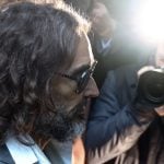Photographers take photos of Russell Brand walking
