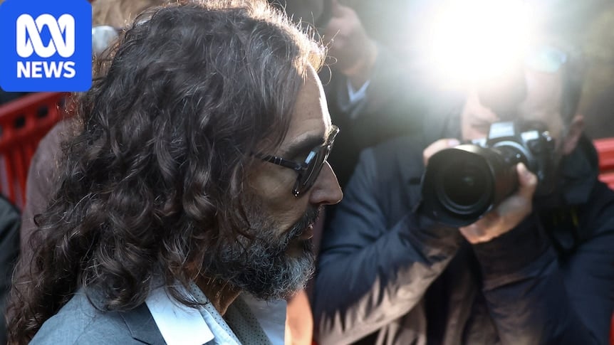 Photographers take photos of Russell Brand walking